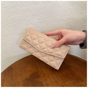 Close-up of beige quilted leather long wallet featuring elegant diamond stitch pattern