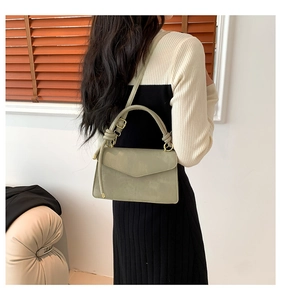 Vista posteriore di una modella con borsa in pelle PU verde salvia e dettagli dorati