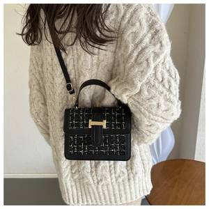 Detail der Tweed-Umhängetasche mit goldener H-Schließe an einem weiblichen Model
