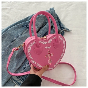 Detail of pink heart bag featuring Baby text, flame print and gothic cross on denim
