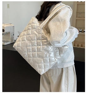 Grand sac fourre-tout matelassé blanc avec bandoulière rembourrée dans un café urbain