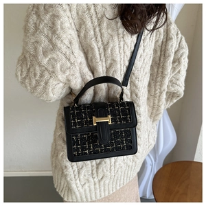 Detail der schwarzen Tweed-Umhängetasche mit goldenen Beschlägen für Damen im Winter