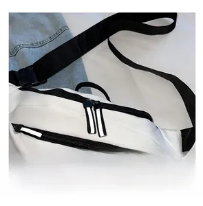 Détail d'un sac de poitrine en tissu oxford blanc avec fermetures éclair noires