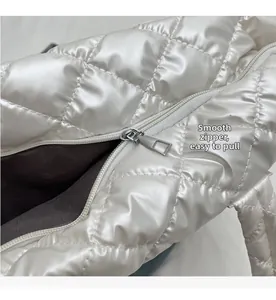 Vue détaillée de la fermeture éclair fluide sur un sac cabas matelassé blanc brillant