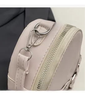 Gros plan détaillé des ferrures argentées et du cuir PU lisse sur le sac à main rose