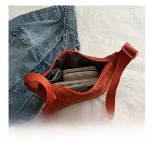 Spacious interior of an orange crescent tote bag showing storage for phone and wallet