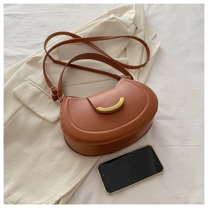 Detail of caramel crescent crossbody bag with gold metal clasp and phone size comparison