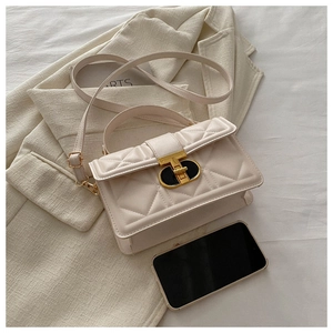 Close-up of quilted PU leather handbag with elegant black and gold rotating lock detail