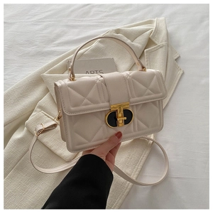 Close-up of quilted beige PU leather bag with premium gold twist lock and elegant texture