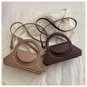 Detail of geometric trapezoid handbags in light brown and dark coffee leather