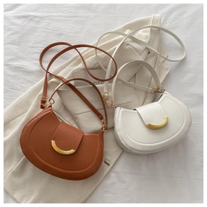 Detailed view of half-moon leather shoulder bags with gold crescent buckles and thin straps