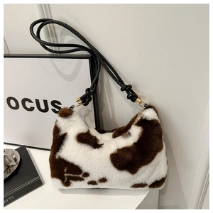 Detailed macro view of plush faux fur shoulder bag with stylish brown cow print pattern