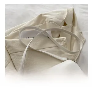 Detail of white leather shoulder bag with a silver rhinestone bow and lobster clasp