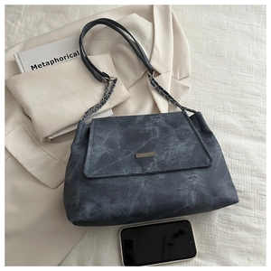 Detail of grey washed texture handbag with silver chain strap and phone size reference
