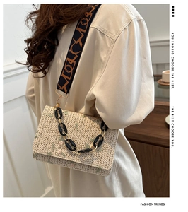 Detailed embroidery on woven straw crossbody bag with stylish chain and wide strap