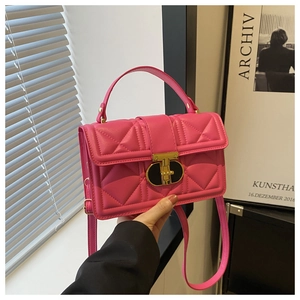 Detail of rose pink quilted PU leather bag featuring a gold-tone T-shaped metal turn lock
