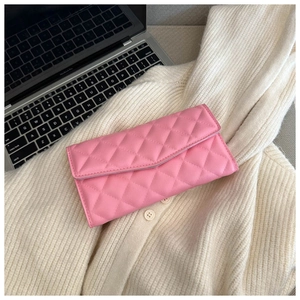 Detailed view of pink quilted rhombus leather texture on an elegant clutch handbag