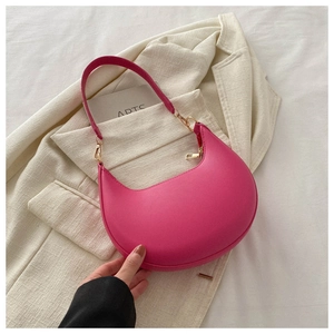 Detail of bright pink PU leather moon bag with gold zipper on cream blazer background