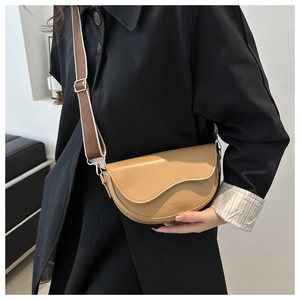 Détail du sac bandoulière demi-lune marron clair avec rabat ondulé et logo doré