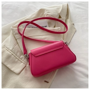 Detail of rose pink faux leather shoulder bag with rhinestones on white blazer