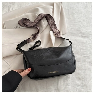 Detail of black retro dumplings bag featuring matte PU leather and wide woven shoulder strap