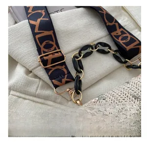 Detail of woven beige handbag with wide geometric strap and gold metal spring hook