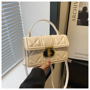 Close-up of quilted cream faux leather bag featuring a designer gold rotary lock