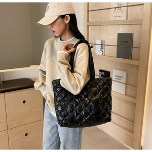 Vue détaillée du sac cabas matelassé noir avec finition brillante et grand volume