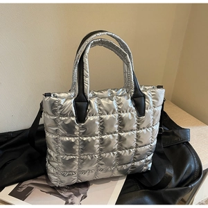 Détail du sac cabas matelassé argenté avec bandoulière noire et poignées renforcées