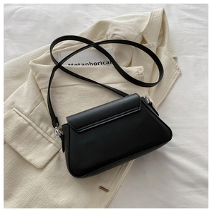 Detail of black leather flap crossbody bag with silver hardware and adjustable strap