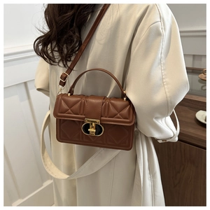 Close-up of brown quilted faux leather bag with vintage gold metal twist lock detail