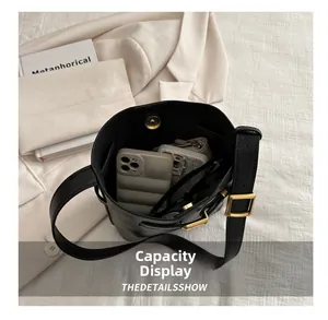 Spacious interior of a black leather bucket bag showing storage for daily essentials