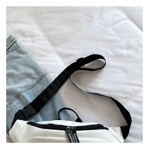 Vue de dessus du sac banane en nylon blanc avec sangle noire et détails zippés