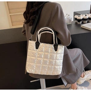 Détail du sac cabas matelassé blanc avec anses noires dans un décor moderne et chic