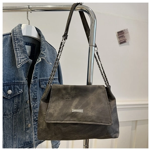 Detail of vintage grey washed canvas bag with metallic logo and silver chain strap