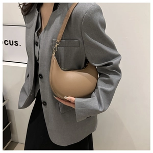 Detail of camel PU leather crescent underarm bag with adjustable strap on model