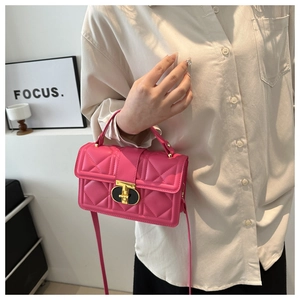 Detail of pink quilted PU leather bag with golden T-lock and adjustable shoulder strap