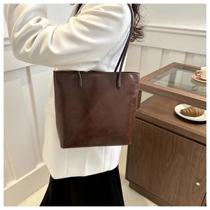 Detailed view of dark brown faux leather tote with vintage texture and glossy finish