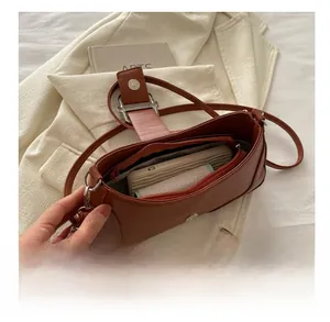 Détail de l'intérieur du sac baguette marron montrant la capacité et la poche zippée