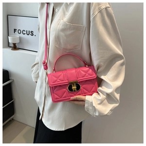 Detail of fuchsia quilted handbag with gold square buckle and adjustable shoulder strap