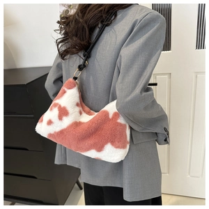 Detail of pink cow print plush shoulder bag with leather strap and knot accent