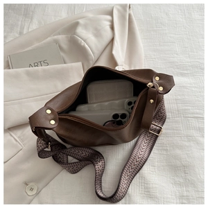Deep brown leather dumpling bag showing large interior capacity for phones and wallet