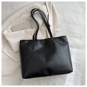 Detailed overhead view of a black matte leather tote bag with long dual shoulder straps