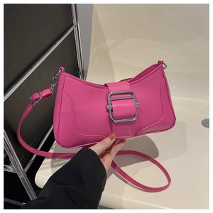 Détail d'un sac baguette rose vif avec une boucle rectangulaire élégante en métal argenté