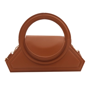 Minimalist brown geometric handbag with a large circular handle and smooth leather finish