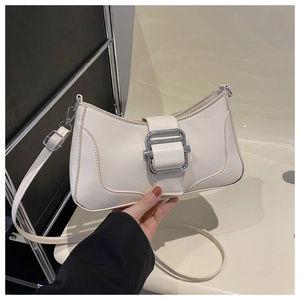 Détail du sac croissant crème avec grande boucle en métal argenté et texture en cuir PU