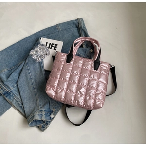 Gros plan d'un sac matelassé rose métallisé avec texture bouffante sur jean bleu