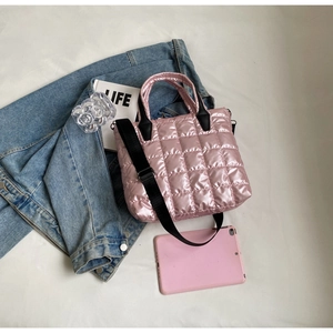 Détail du sac matelassé rose avec sangles noires et texture en nylon métallique doux