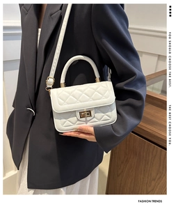 Détail d'un mini sac matelassé blanc avec fermoir rotatif doré et bandoulière chic