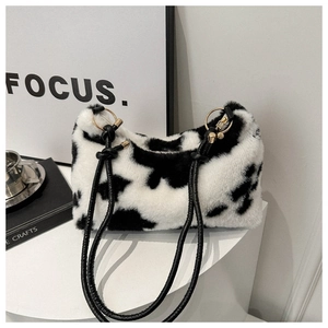 Minimalist plush shoulder bag with black and white cow print and slim leather straps